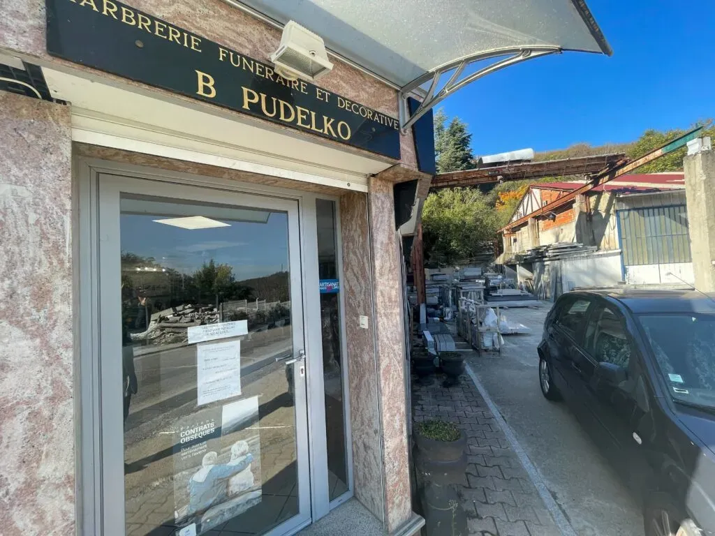 Entrée vitrée de la Marbrerie B. Pudelko avec enseigne dorée et accès à la cour de stockage
