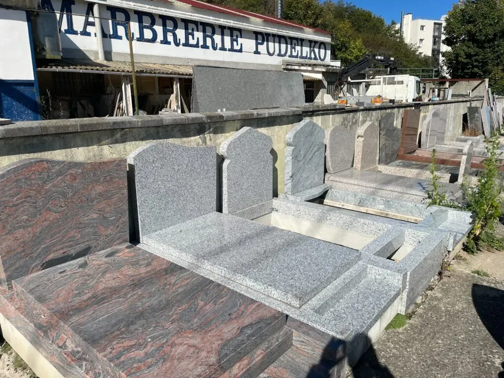 Parc d'exposition extérieur présentant divers modèles de monuments et stèles funéraires