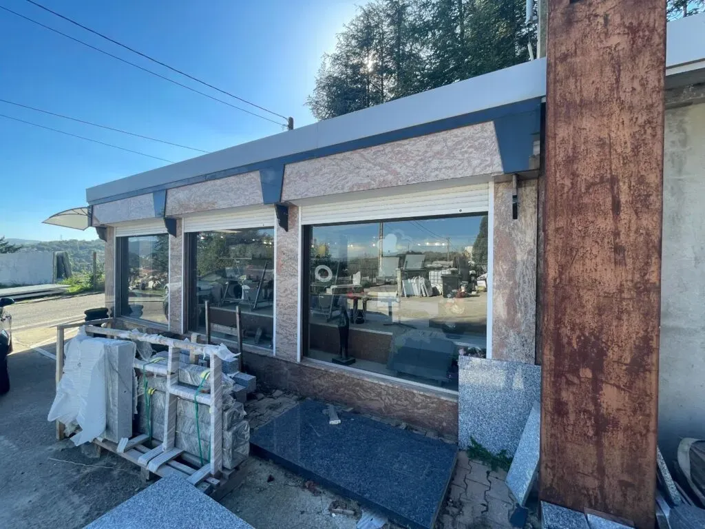 Façade en granit rose de la boutique avec vitrines et blocs de marbre exposés